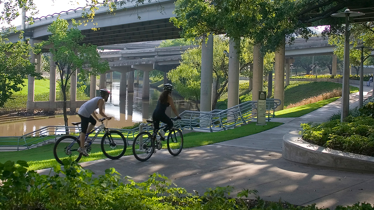 Bicyclists use the trails at Buffalo Bayou Promenade, a park found under highway infrastructure.